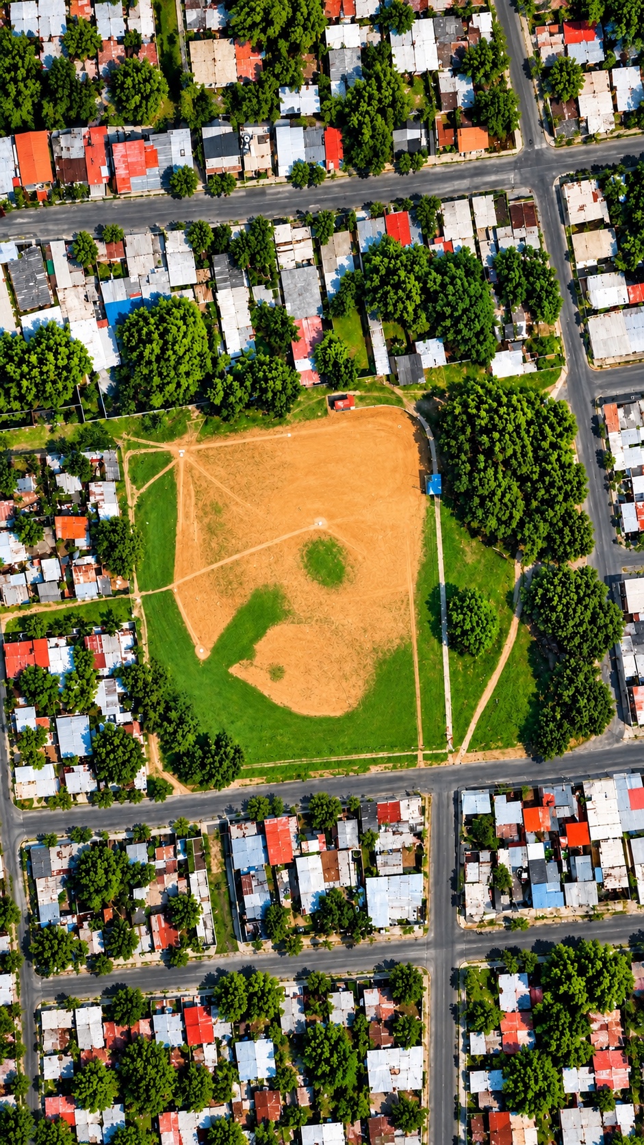 Vista aérea de un campo de béisbol rodeado de casas