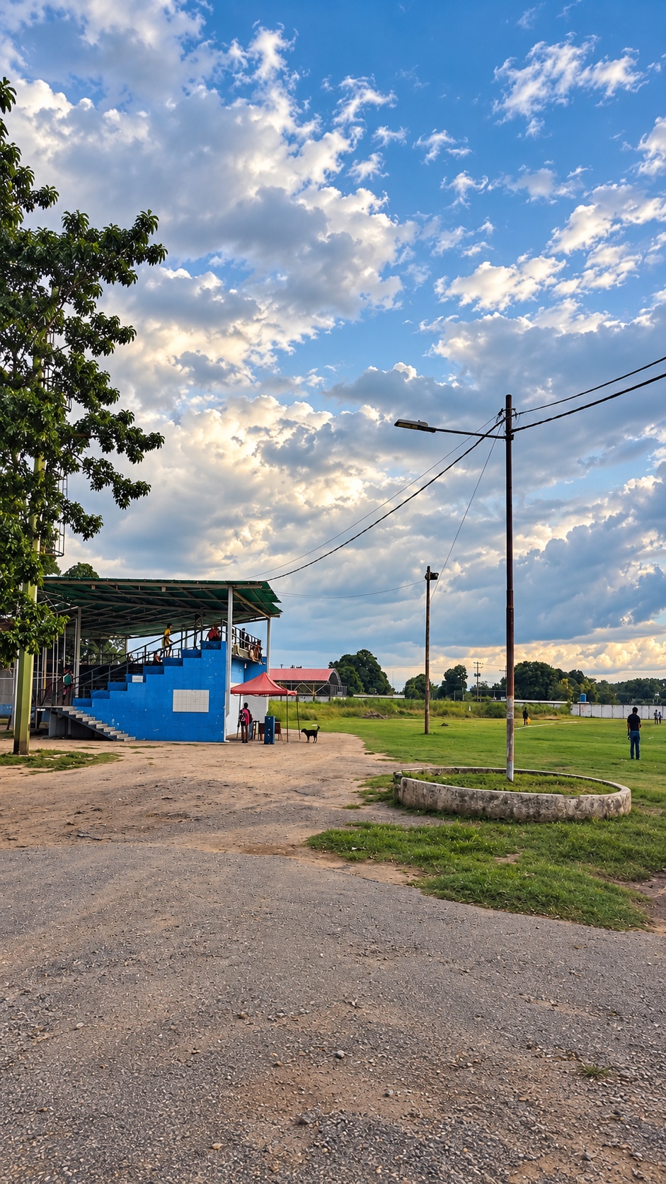Gradas azules techadas del Polideportivo de La Libertad junto al campo de grama